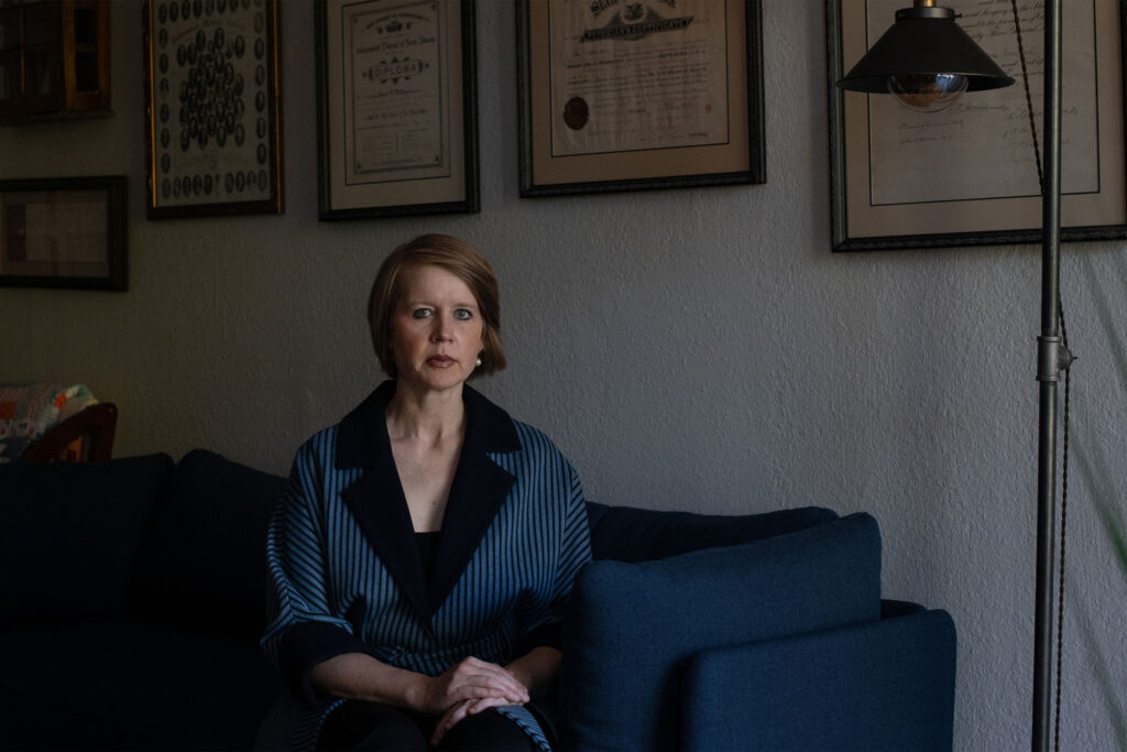 A photo of a woman sitting in her home.