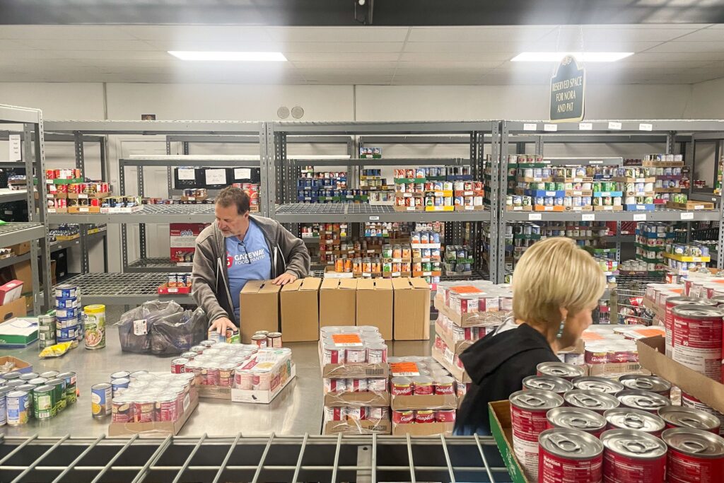 A man sorts through a food delivery at a food bank